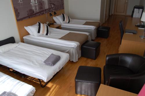 a group of three beds in a room with a chair at Sure Hotel by Best Western City Jonkoping in Jönköping