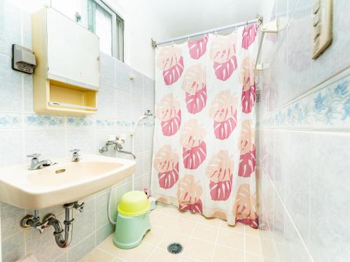a bathroom with a sink and a shower curtain at Nabee no Yado B057 in Onna