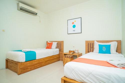 Un pat sau paturi într-o cameră la Sans Hotel Zam-Zam Syariah Palangkaraya
