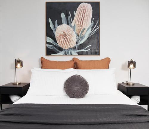 a bedroom with a white bed with two lamps at Pokolbin Farm Stay in Pokolbin