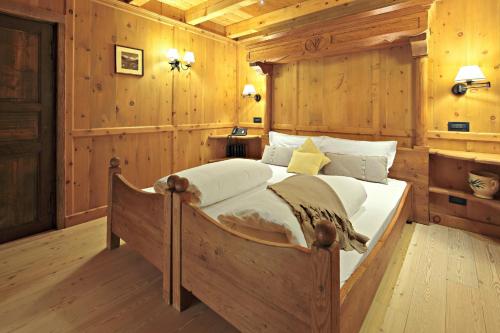 a bedroom with a bed in a wooden room at Hotellerie De Mascognaz in Champoluc