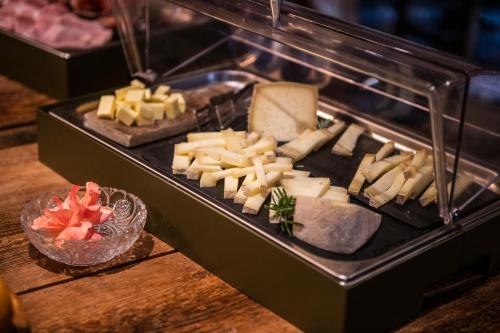 a grill with cheese and other foods on a table at Brieis Relais Alpino in Marmora