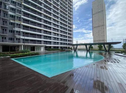a large swimming pool in the middle of a building at Cozy Bedroom FAME Condo Greenfield EDSA MRT Shaw in Manila
