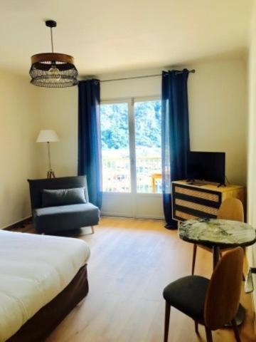 een slaapkamer met een bed, een stoel en een raam bij Appartements Les résidences du port La Siesta in Porto Ota