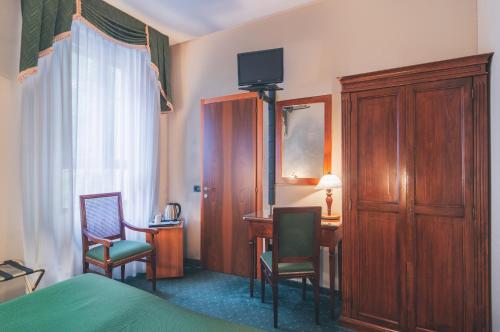 a hotel room with a bed and chairs and a desk at Hotel Al Malcanton in Venice