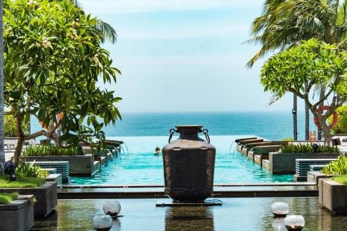 a pool at a resort with a vase in the water at Narada Resort & Spa Perfume Bay Sanya - All Villas in Lingshui