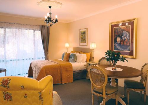 a hotel room with a bed and a table and chairs at Rosewood Guesthouse in Margaret River Town