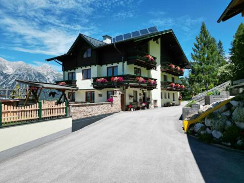 a large white house with a black roof at Mitterwallnerhof in Schladming