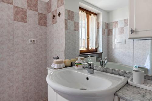 y baño con lavabo blanco y bañera. en Appartamento Lucia, en Baselga di Pinè