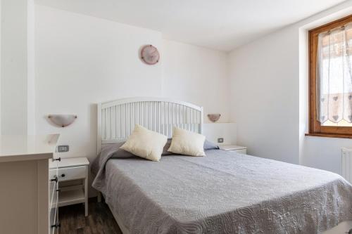 Habitación blanca con cama y ventana en Appartamento Lucia, en Baselga di Pinè