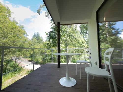 a balcony with a table and chairs on a deck at Coboushi オモヤ in Niseko