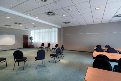 a conference room with chairs and a projection screen at Seminaris Hotel Nürnberg in Nürnberg