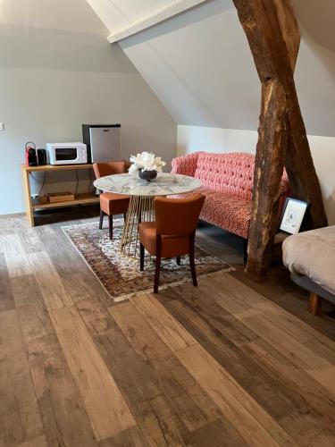 a living room with a table and a couch at Le Domaine des Bois in Blangy-le-Château