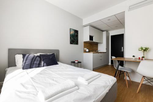 a bedroom with a large white bed and a desk at Bright Work&Study Studio with Rest Area in Tallinn