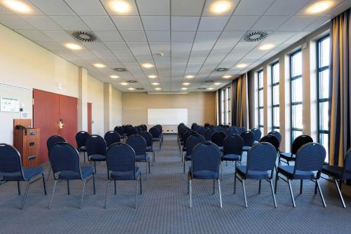 a room with rows of chairs and a podium in a classroom at Seminaris Hotel Nürnberg in Nürnberg