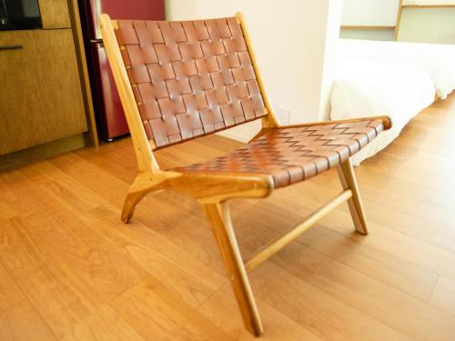 a brown chair sitting on a wooden floor at Coboushi ハナレ in Niseko