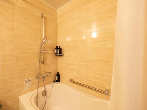 a bathroom with a shower and a bath tub at Coboushi ハナレ in Niseko