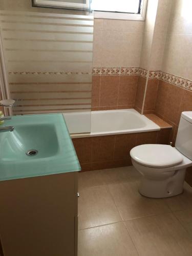 a bathroom with a tub and a toilet and a sink at Apartament La Calita in Peniscola