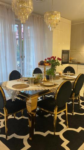 a dining room with a table and chairs and chandeliers at La Rose Residence in Mikołajki