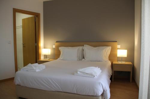 1 dormitorio con 1 cama blanca grande y 2 lámparas en JP HOUSE en Nelas