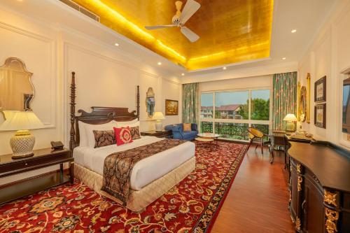 a bedroom with a king sized bed and a desk at MAYFAIR Tea Resort in Siliguri