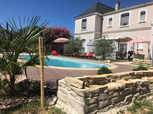 - une piscine en face d'une maison dans l'établissement LA VILLA BOLERO, à Saint-Cyr-sur-Loire