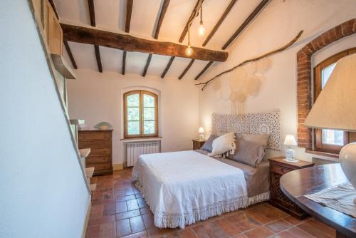 Schlafzimmer mit einem Bett, einem Tisch und Fenstern in der Unterkunft Casa indipendente nel Chianti in Castelnuovo Berardenga