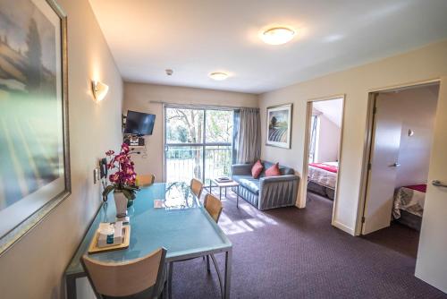 a living room with a table and a couch at Kings Of Riccarton Motel- Close to Railway Station and Airport with Shuttle service in Christchurch