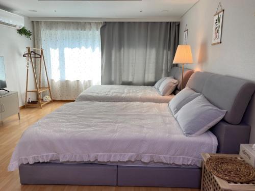 a bedroom with two beds and a couch at Hongdae Residence 3 - 1min from Hongik Uni station Exit #1 in Seoul