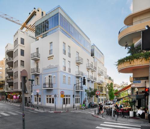 un alto edificio bianco su una strada di città con un passaggio pedonale di Alberto by Isrotel Design a Tel Aviv