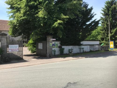 a house with a fence and a tree next to a street at Métris 2/3 in Corre