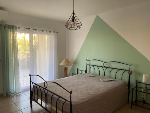 ein Schlafzimmer mit einem Bett und einem großen Fenster in der Unterkunft Très bel appartement entier proche de la mer 2 chambres 1 salon in Vallauris