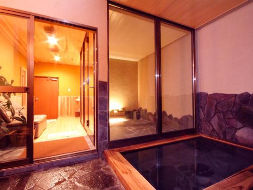 een kamer met grote glazen ramen en een woonkamer bij Hozanso Beppu in Beppu