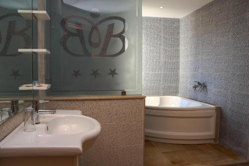 a bathroom with a sink and a tub and a toilet at Hotel Byzance in Nabeul