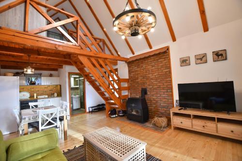 a living room with a television and a brick wall at Brvnara Vila Promaja in Kladovo