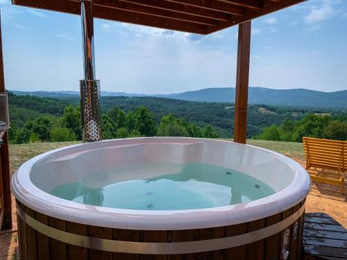 a large wooden tub sitting on a patio with a view at Vila Promaja in Kladovo