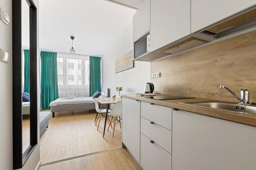a kitchen with a sink and a room with a bed at Bright Work&Study Studio with Rest Area in Tallinn