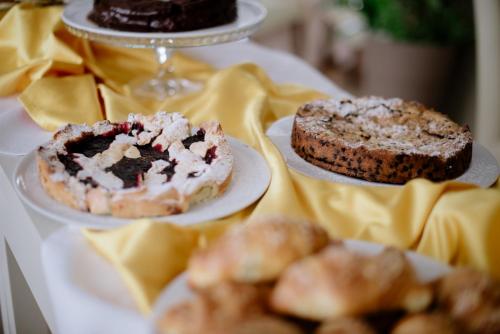 two different types of cakes and pastries on plates on a table at Maison Hotel Lalla in Cesenatico