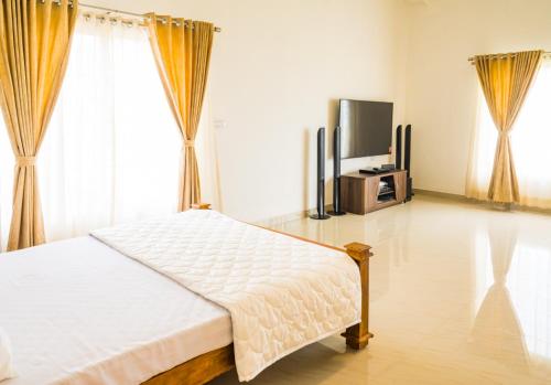 Schlafzimmer mit einem Bett und einem Flachbild-TV in der Unterkunft Tinton Hillstay in Chikmagalur