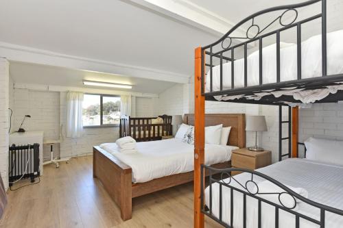 1 Schlafzimmer mit 2 Etagenbetten und einem Schreibtisch in der Unterkunft Sunshine Shores in Morisset East
