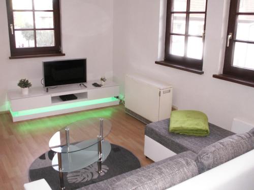 ein Wohnzimmer mit einem Sofa und einem TV in der Unterkunft Ferienhaus Eberbach in Eberbach