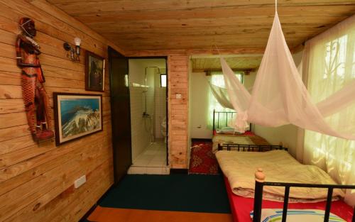 a room with two beds and a shower in a cabin at Arusha Safari Hostel in Arusha