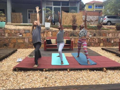 a group of three people doing yoga on mats at Zion INN in Kigali