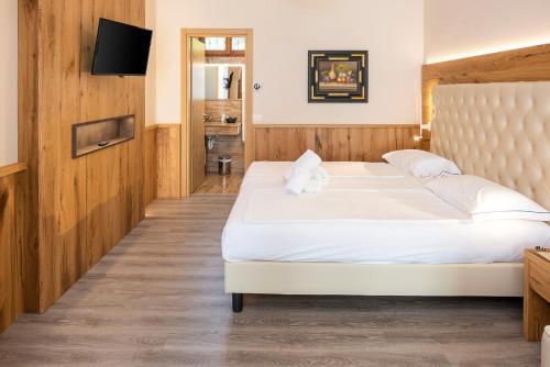 a bedroom with two beds and a flat screen tv at Hotel Du Parc in Garda
