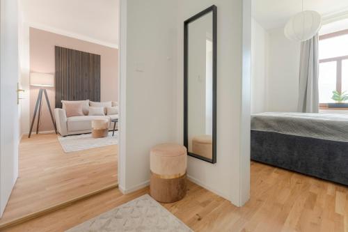 sala de estar con espejo y cama en City Lounge Appartement am Hauptbahnhof, en Sankt Pölten