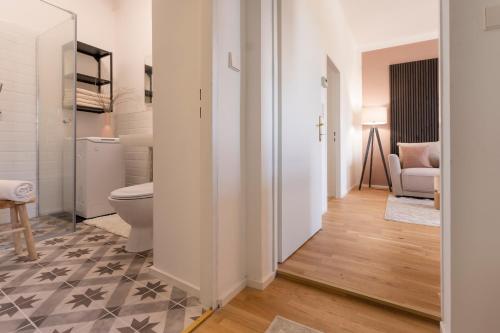 a bathroom with a toilet and a couch in a room at City Lounge Appartement am Hauptbahnhof in Sankt Pölten