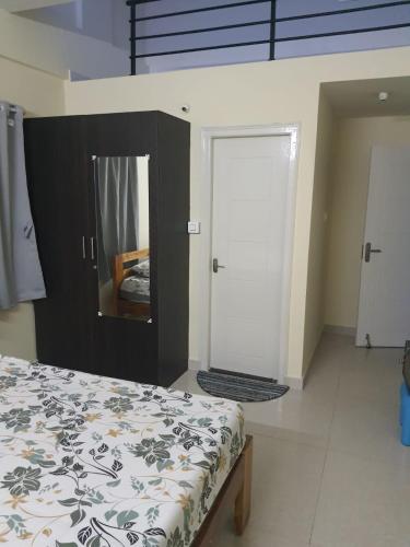 a bedroom with a bed and a mirror and a door at JP Deluxe in Bengaluru