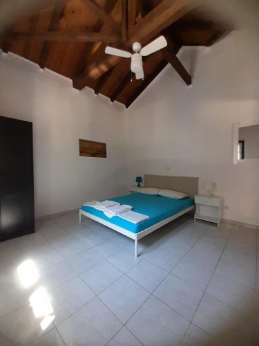 sypialnia z łóżkiem i wentylatorem sufitowym w obiekcie Stafida Guesthouse - Myrtò w mieście Finikounda