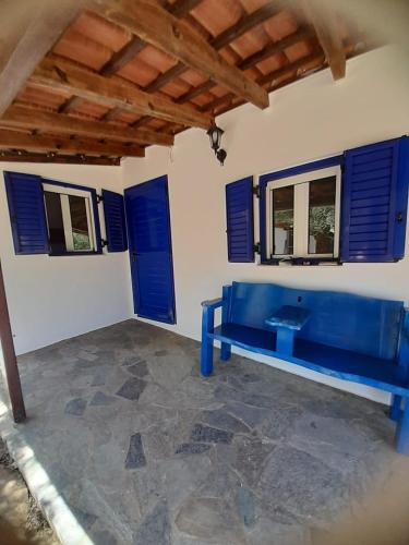 un banco azul en una habitación con ventanas azules en Stafida Guesthouse - Myrtò, en Finikounta