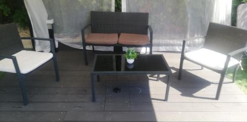 two chairs and a table with a potted plant on a patio at Mansarda con vista lago in Sulzano